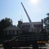 Removing earthquake-damaged chimney with crane.